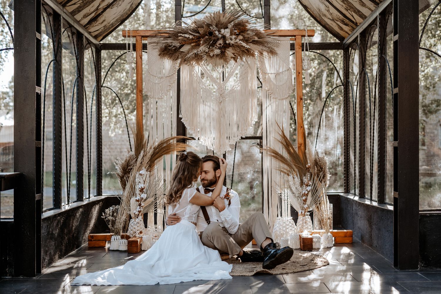 Wedding styled scene in a glass greenhouse with dried floral arrangements.