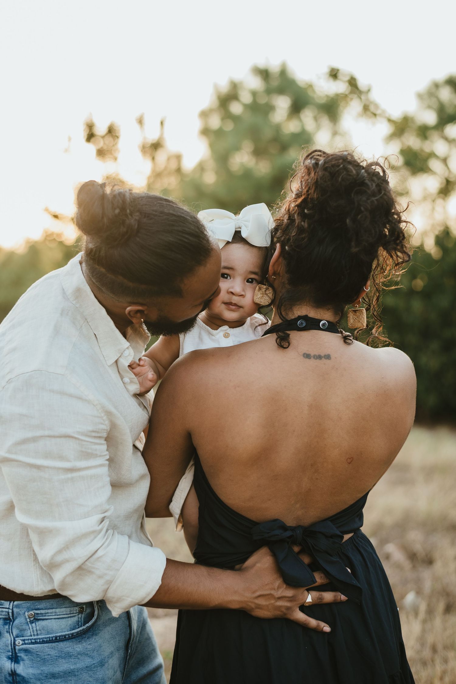 A tender family moment captured outdoors during golden hour.