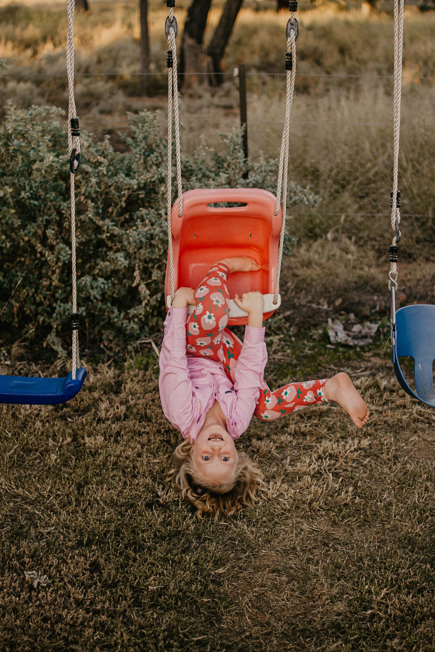 rural kid playing on the swings in her backyard