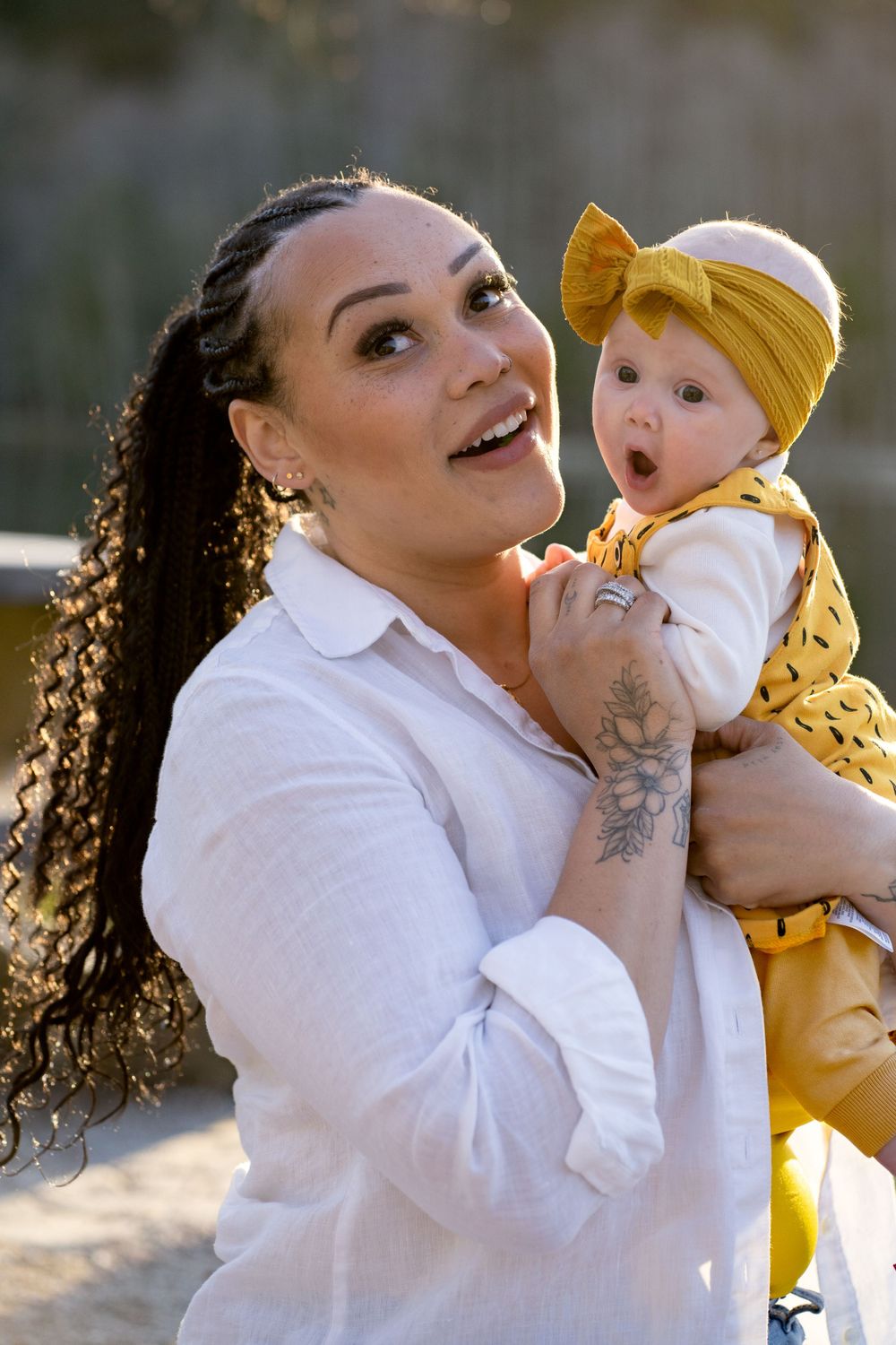 A joyful outdoor portrait featuring two people in white and yellow clothing sharing a happy moment together.