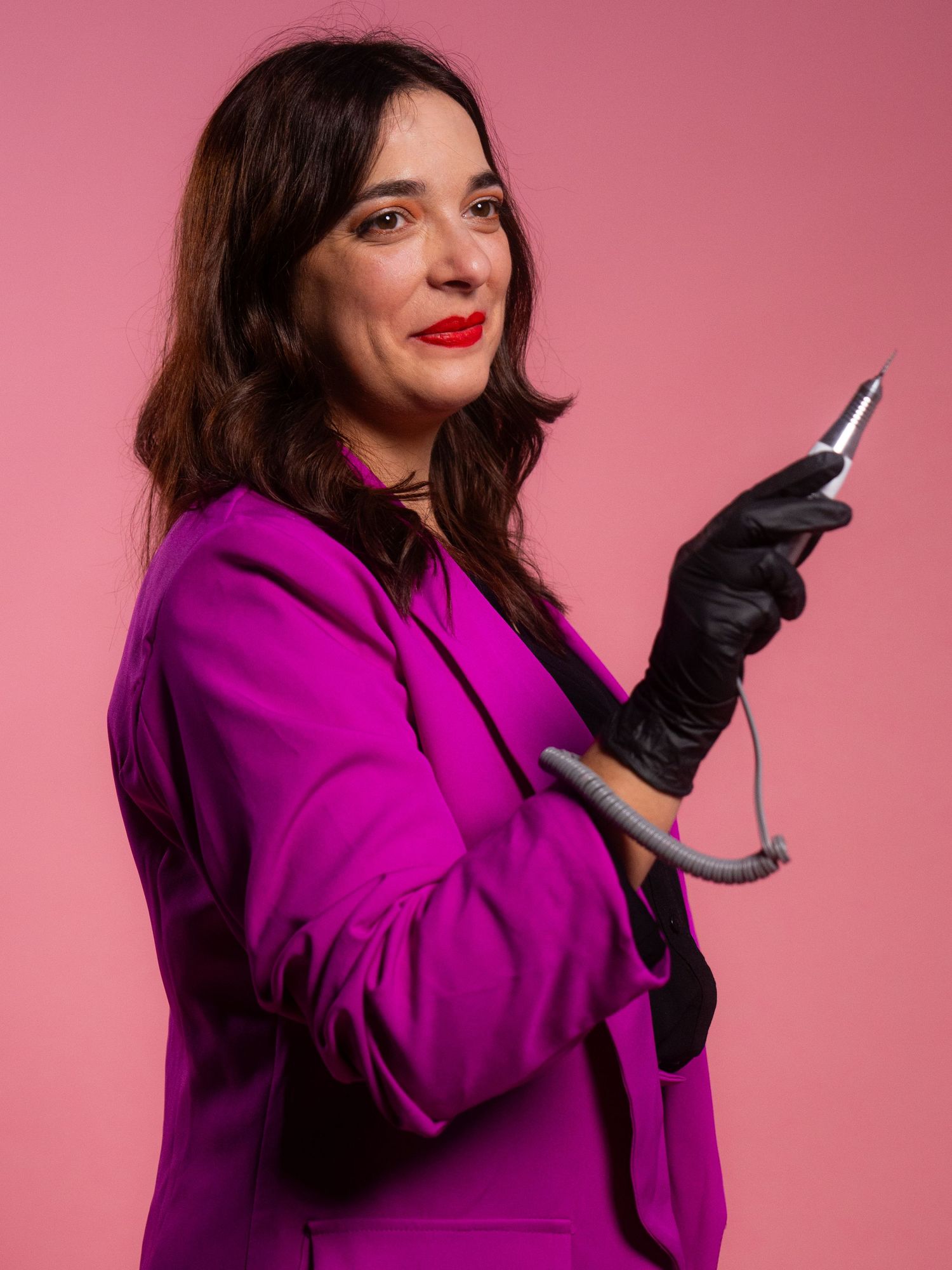 Dynamic poses in magenta coat and black gloves against pink studio backdrop.