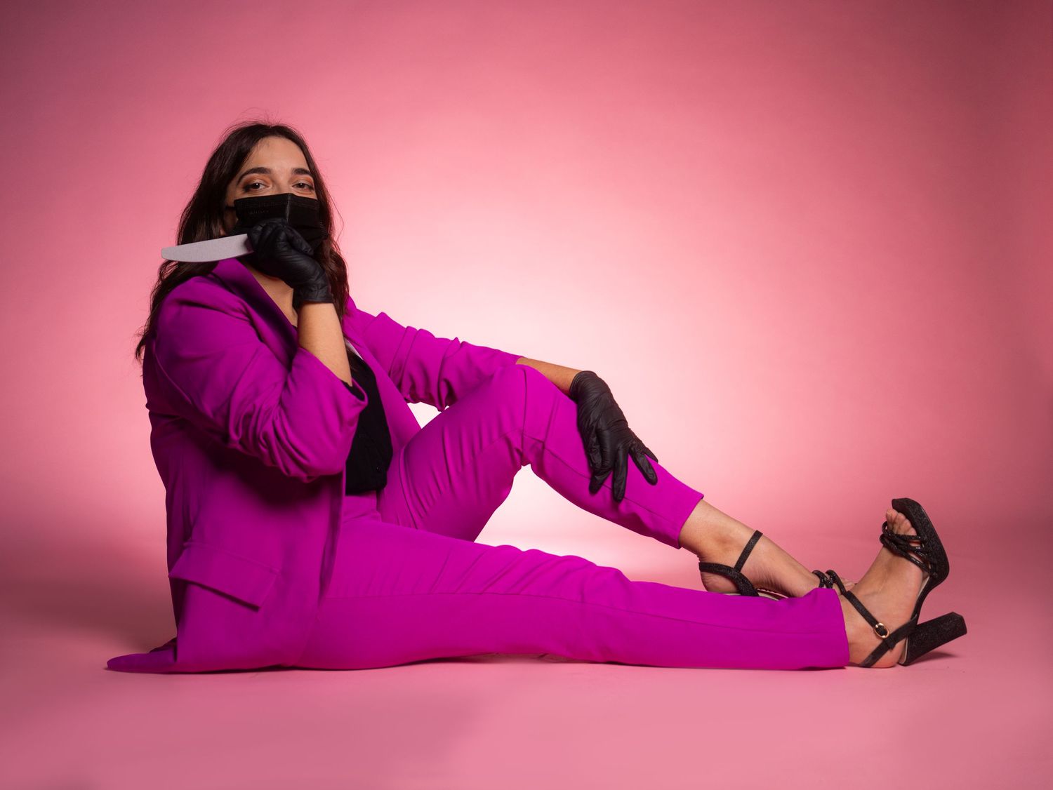 Fashion model poses in bright magenta outfit against pink backdrop in creative positions.