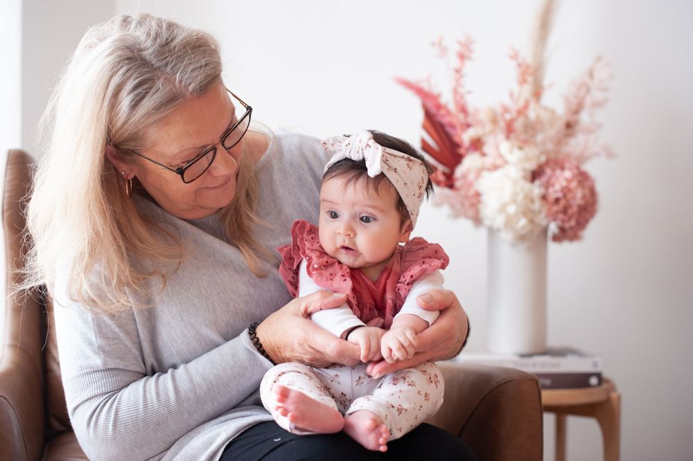 An intimate indoor portrait of a baby wearing pink being held on a brown armchair.
Altona Family Photographer Melbourne