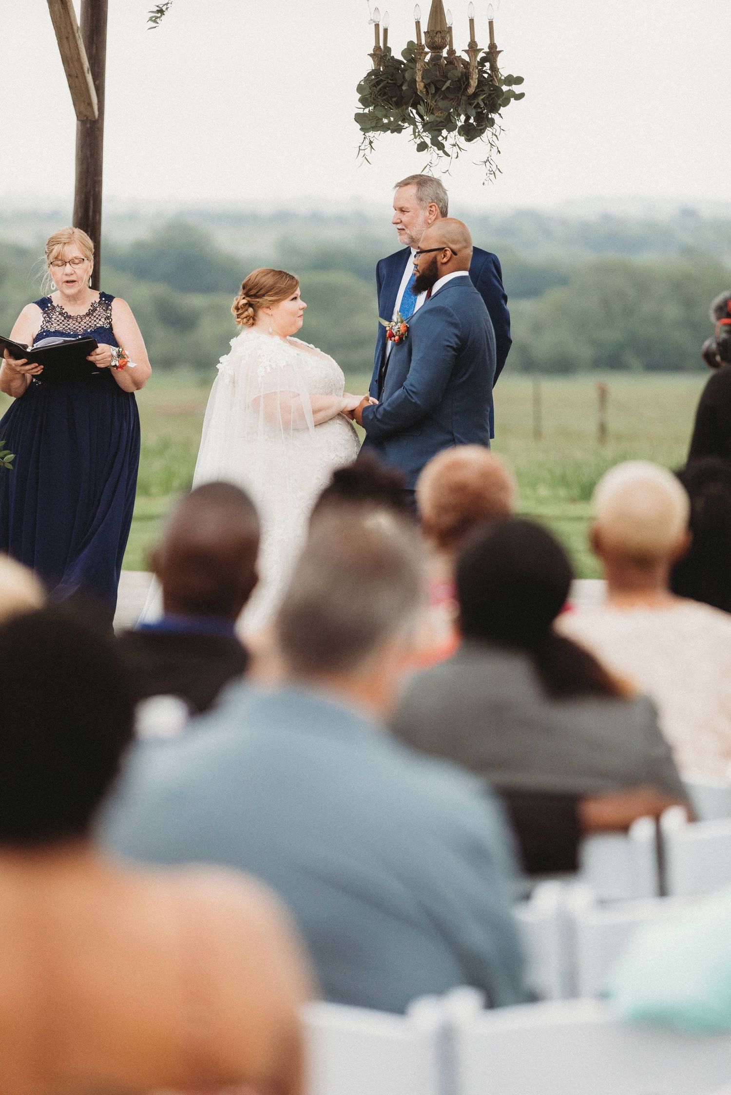 bride and groom holding hands during their ceremony at The Barn at Wolf Ridge Farm