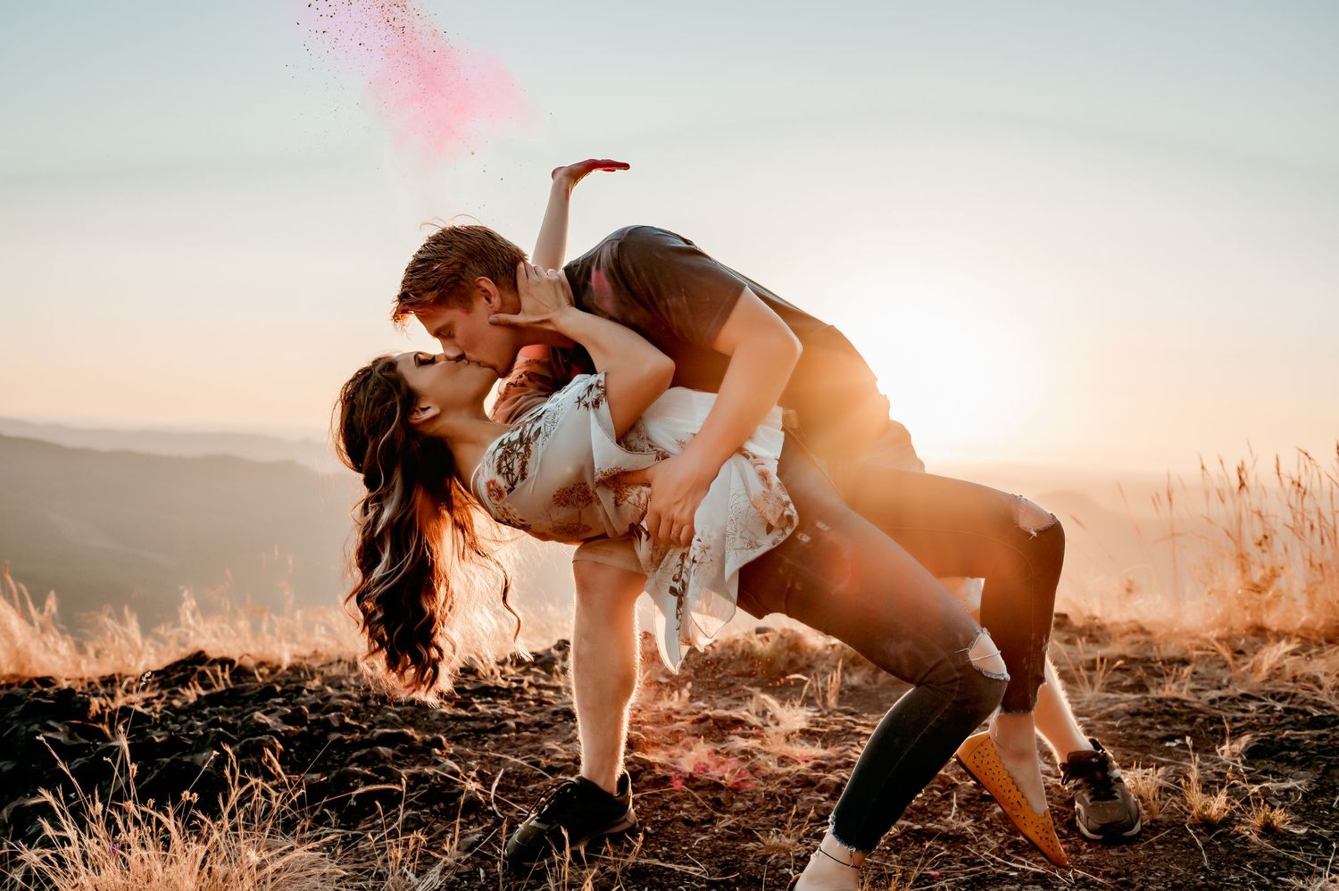 Couple embraces during sunset photoshoot in outdoor setting.