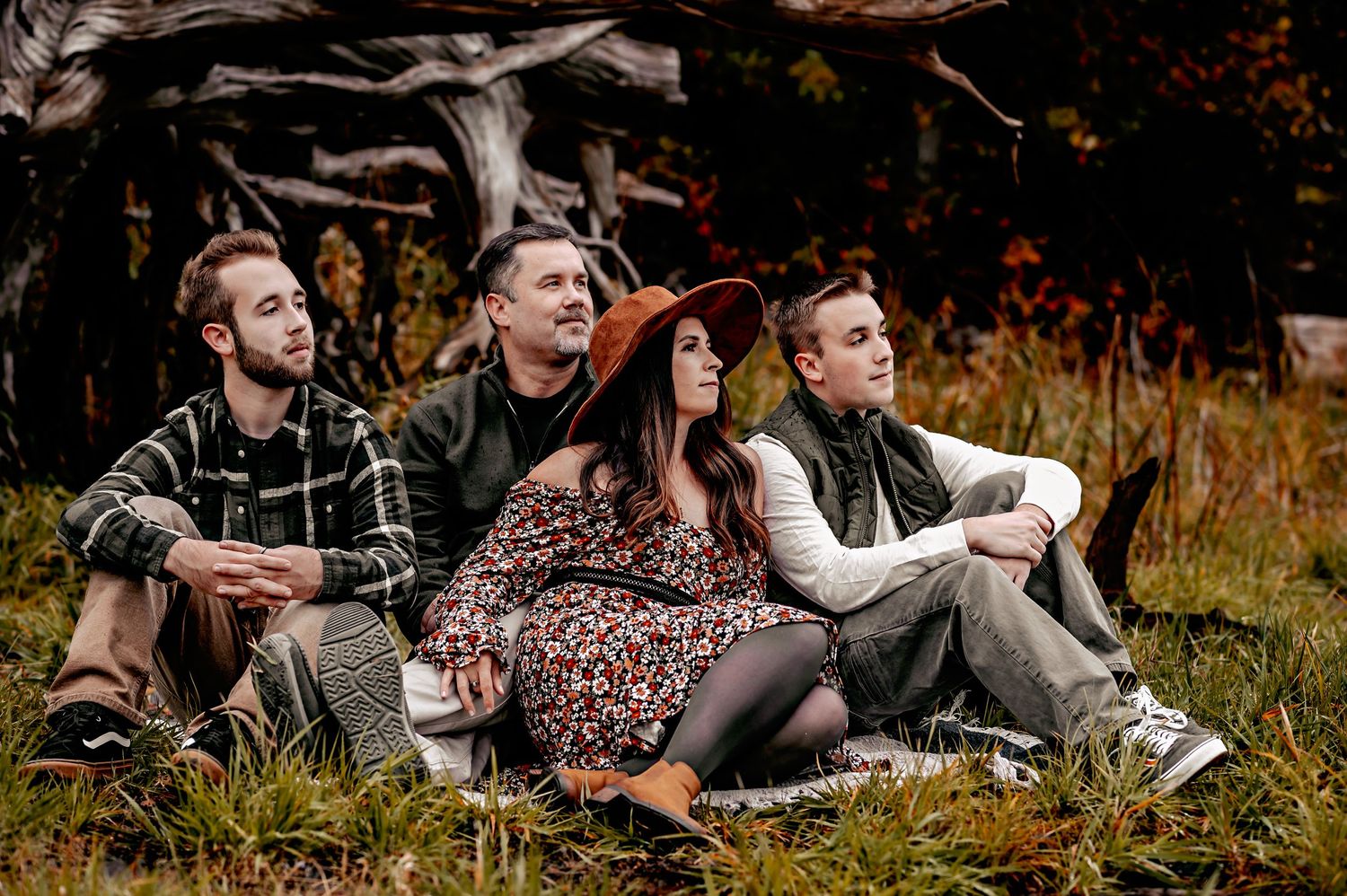 Group relaxing together on autumn grass during outdoor gathering.