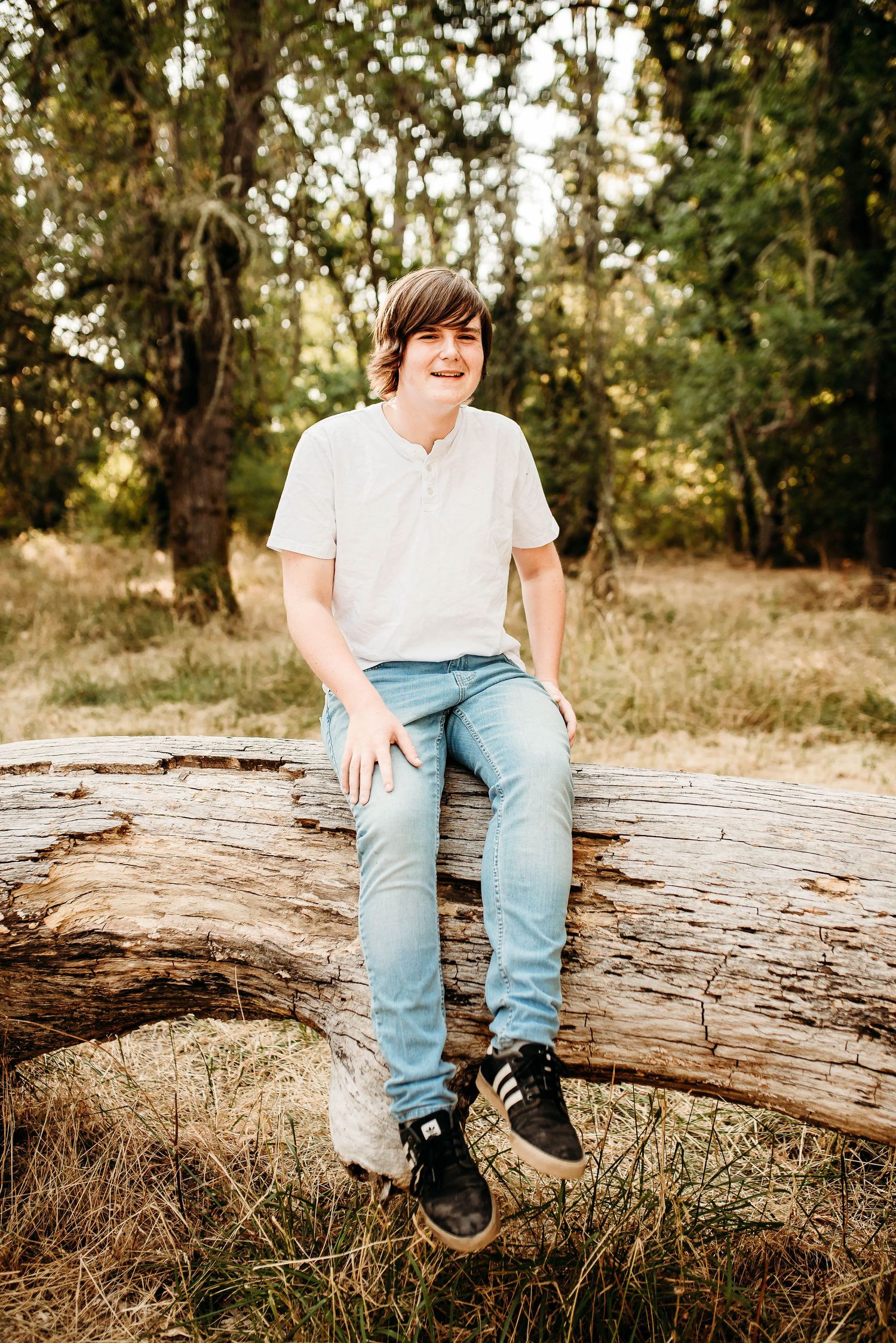 Several close-up shots of someone sitting on a weathered log wearing jeans and casual shoes.
