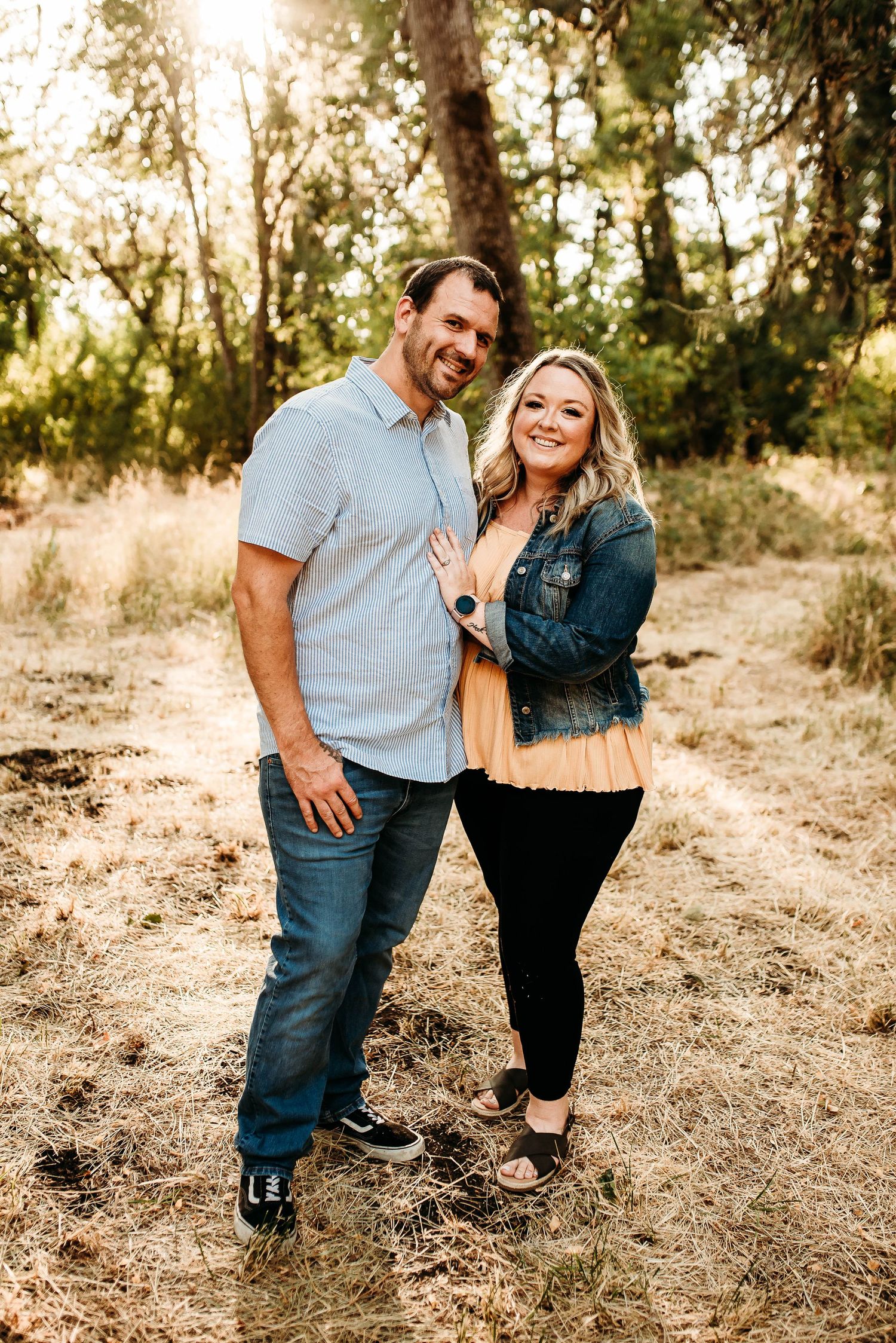 Couple sharing joyful moments together in a sun-lit field.