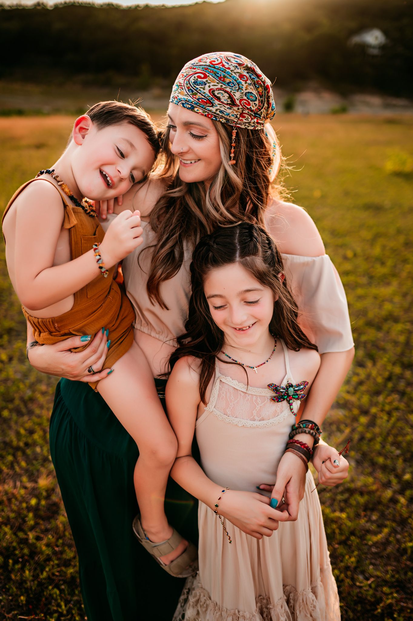 Family sharing tender moments together in a sunlit field at golden hour.
