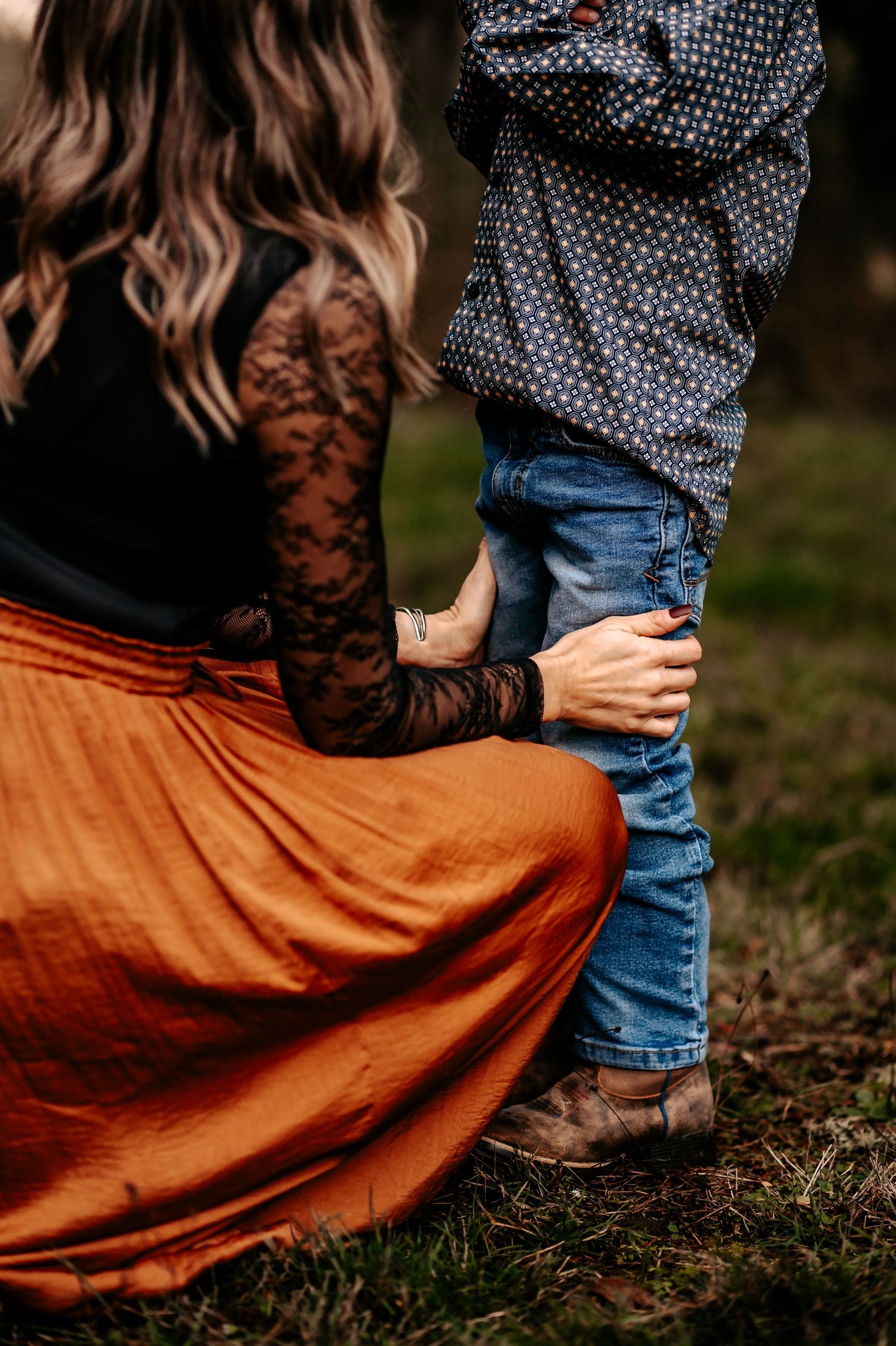 Close-up of autumn fashion details showing lace, knit sweater, and rust-colored skirt.
