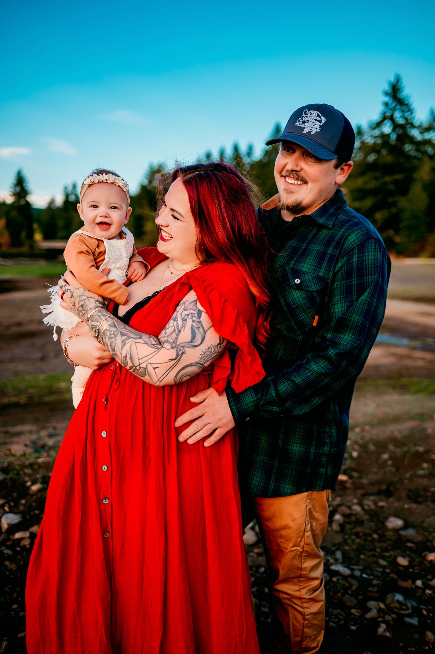 Family photos outdoors with bright red dress and casual attire against natural backdrop.