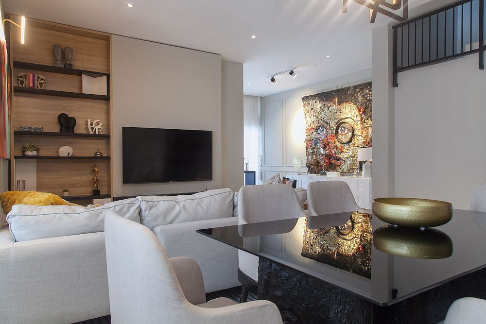 Modern living room with floating shelves, grey sectional sofa, and contemporary artwork on white walls.