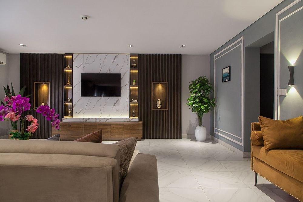 Elegant living room with marble flooring, wood paneling, and modern lighting fixtures.