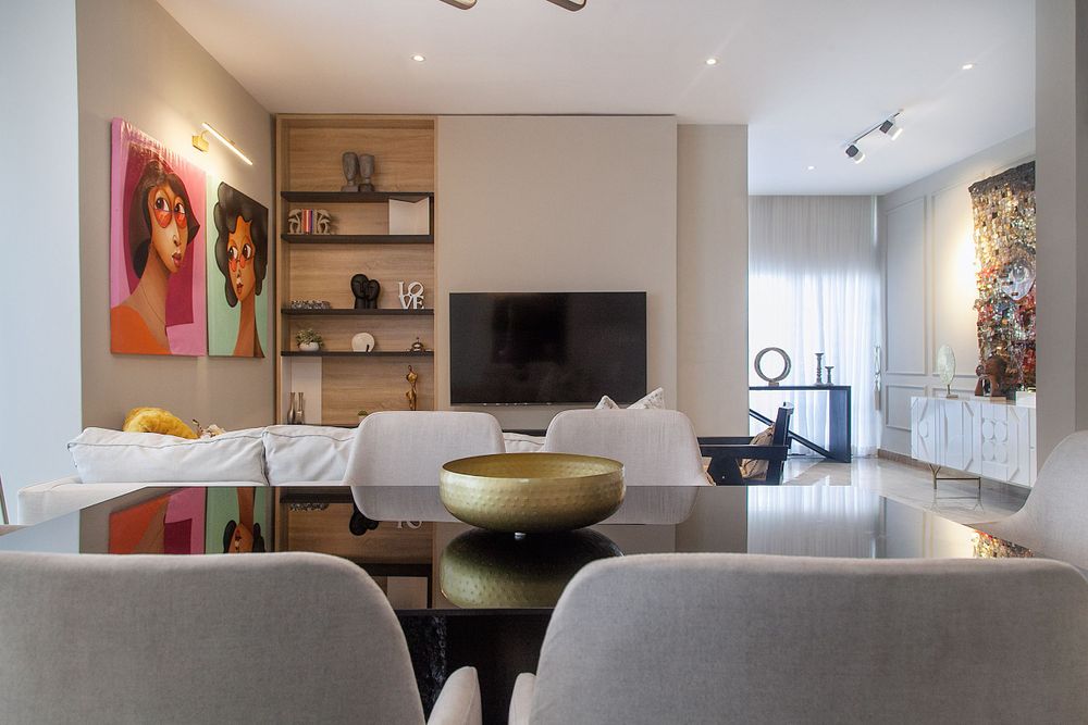 Open concept living space with modern furnishings and artistic wall decor in neutral tones.