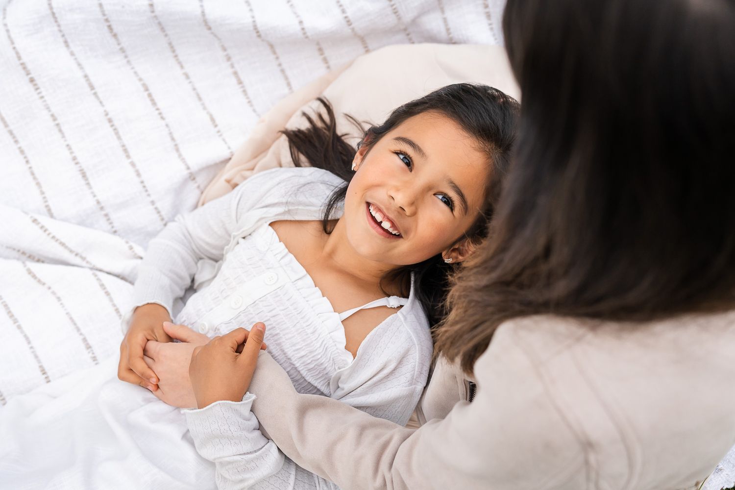 Daughter smiling and looking up at mother during Kirkland family photography session