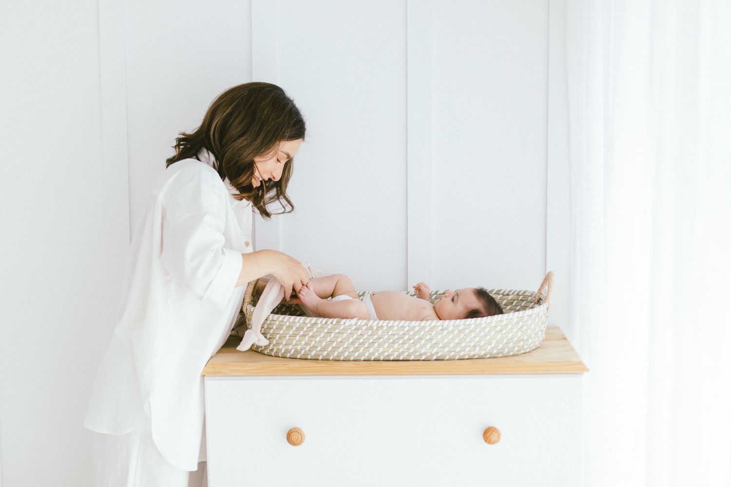 Modern nursery setup with changing table and natural decor elements.