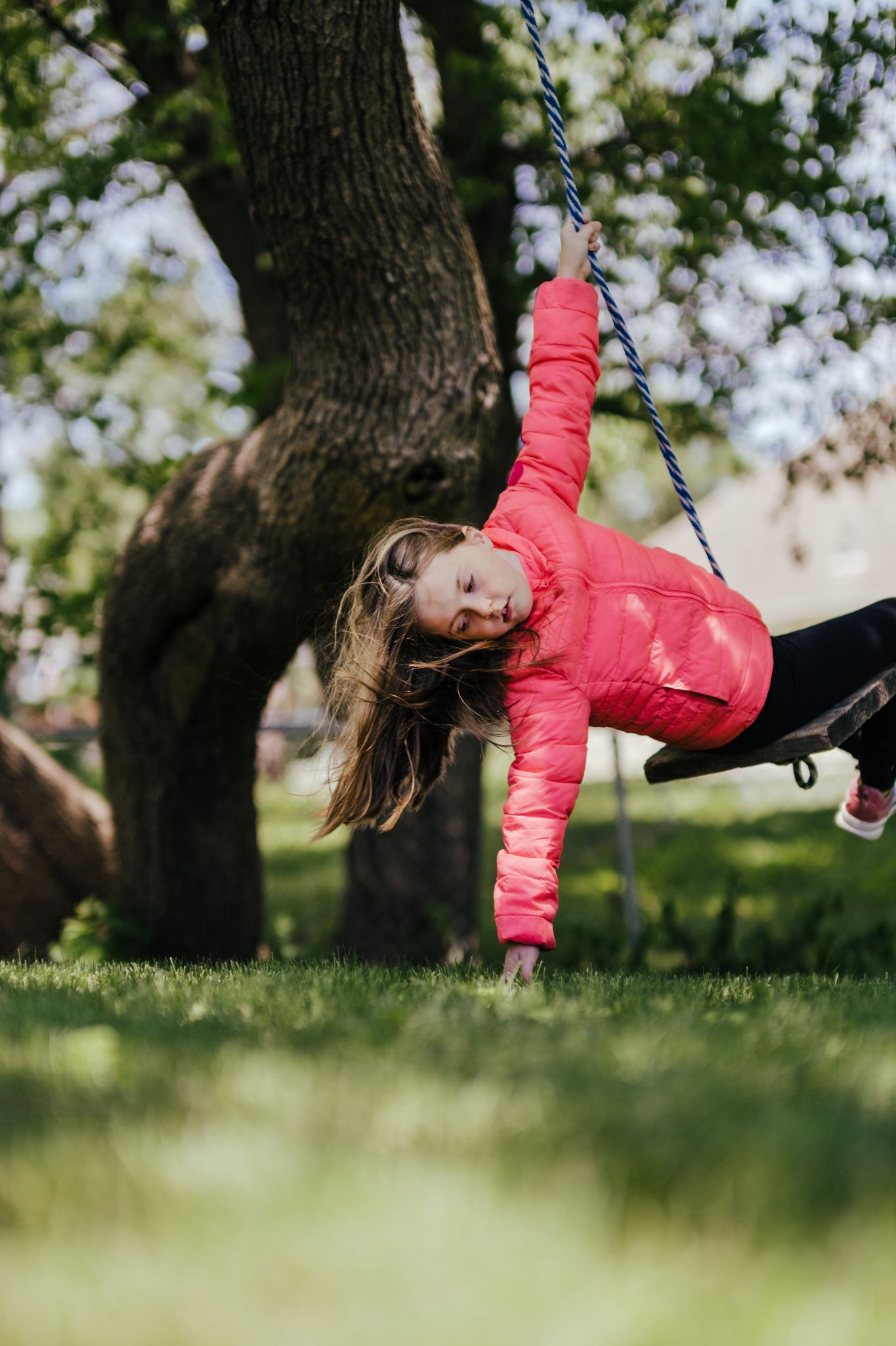 A little girl is on a swing in a photo by Tiffany Arnold Photography in Bentonville, Arkansas