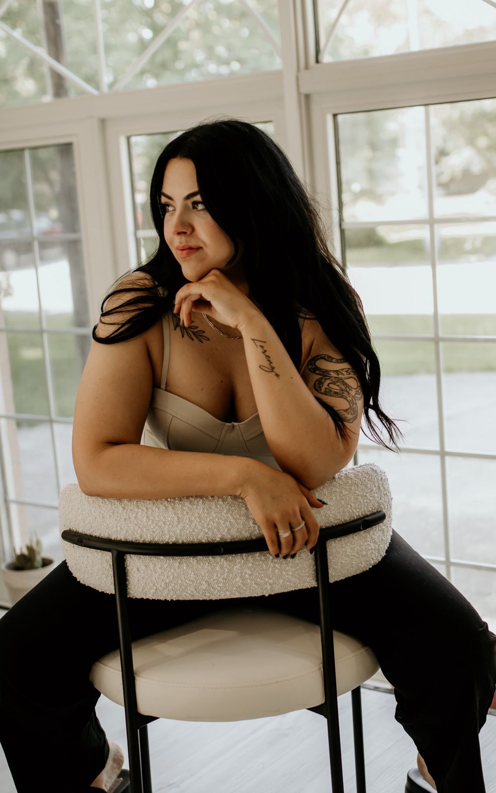 Lifestyle portrait in sunlit room with white chair and modern decor.