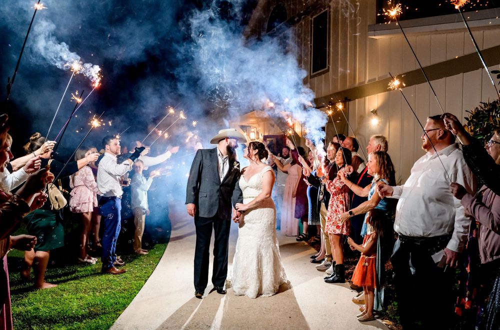 Wedding sparkler exit with guests creating a magical pathway of lights for the newlyweds.