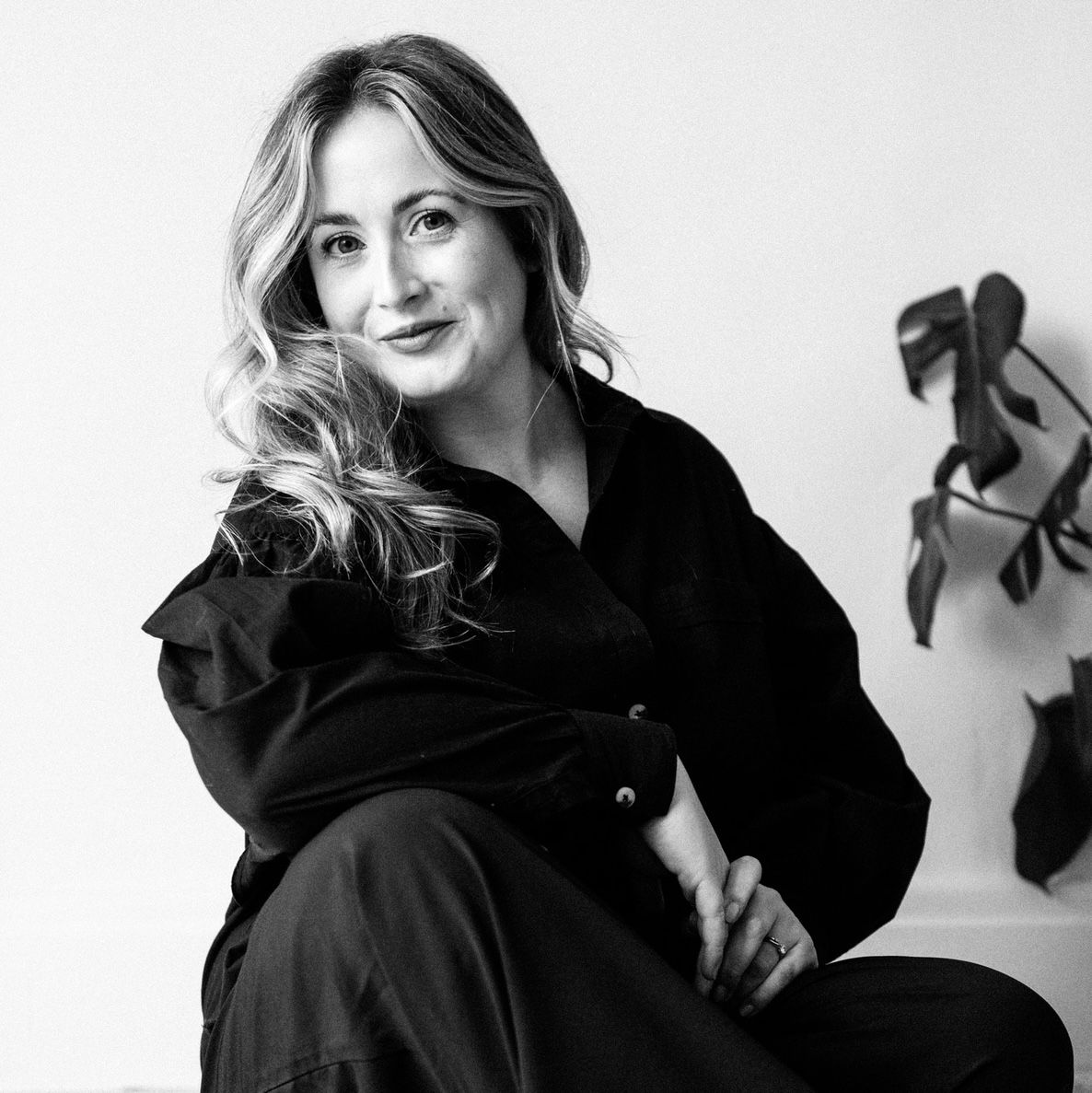 Professional headshots showing different poses in black sweater and striped pants against neutral background.