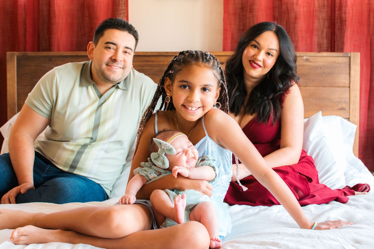 natural light family photo on bed with newborn baby