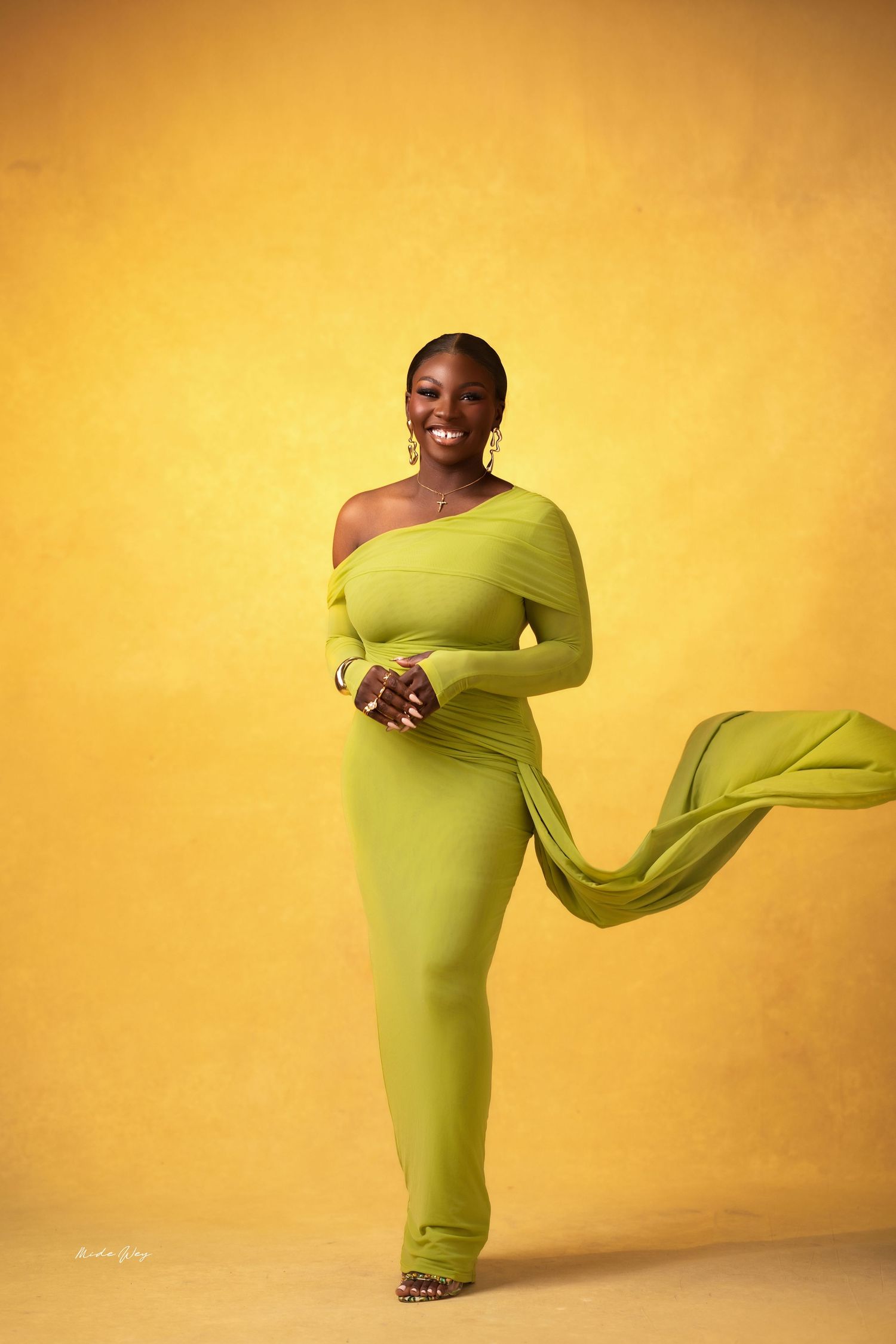 A dancer in a lime green dress moves gracefully through a series of dynamic poses against a warm yellow backdrop.