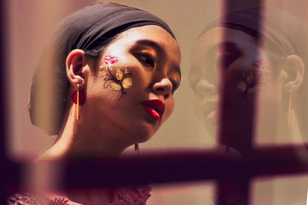 portrait photography of female model looking at her own reflection in the mirror