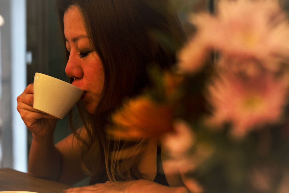Portrait photography of a female model in an indoor cafe drinking a cup of coffee