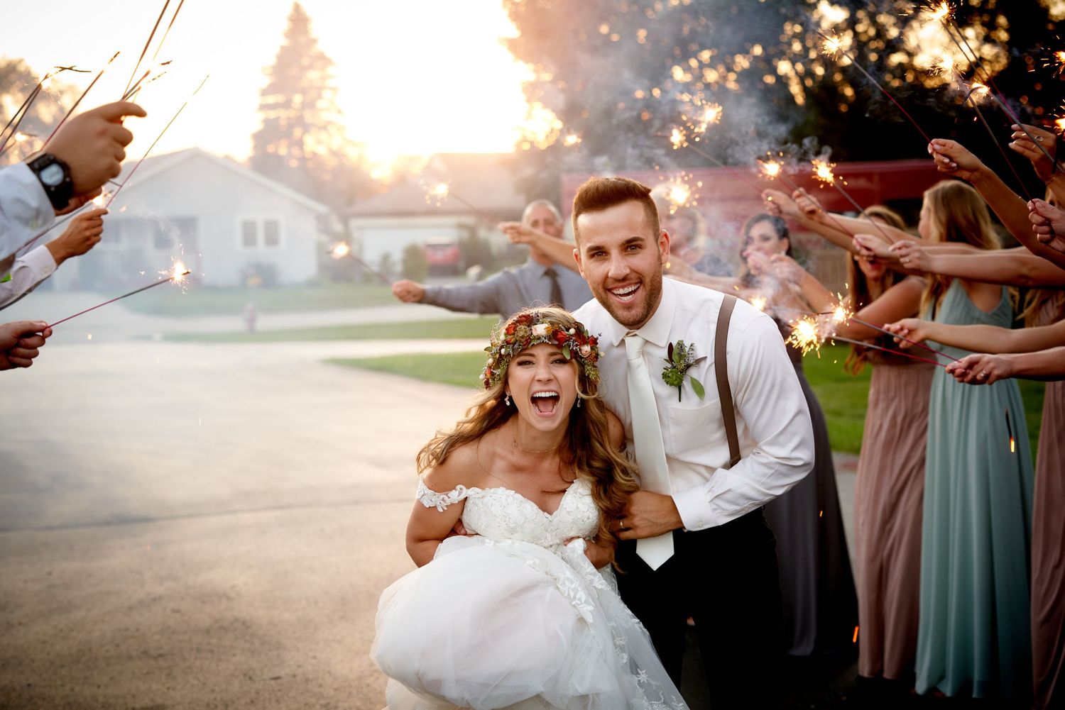A romantic couple shares an intimate dance moment under glowing string lights at an evening wedding reception.