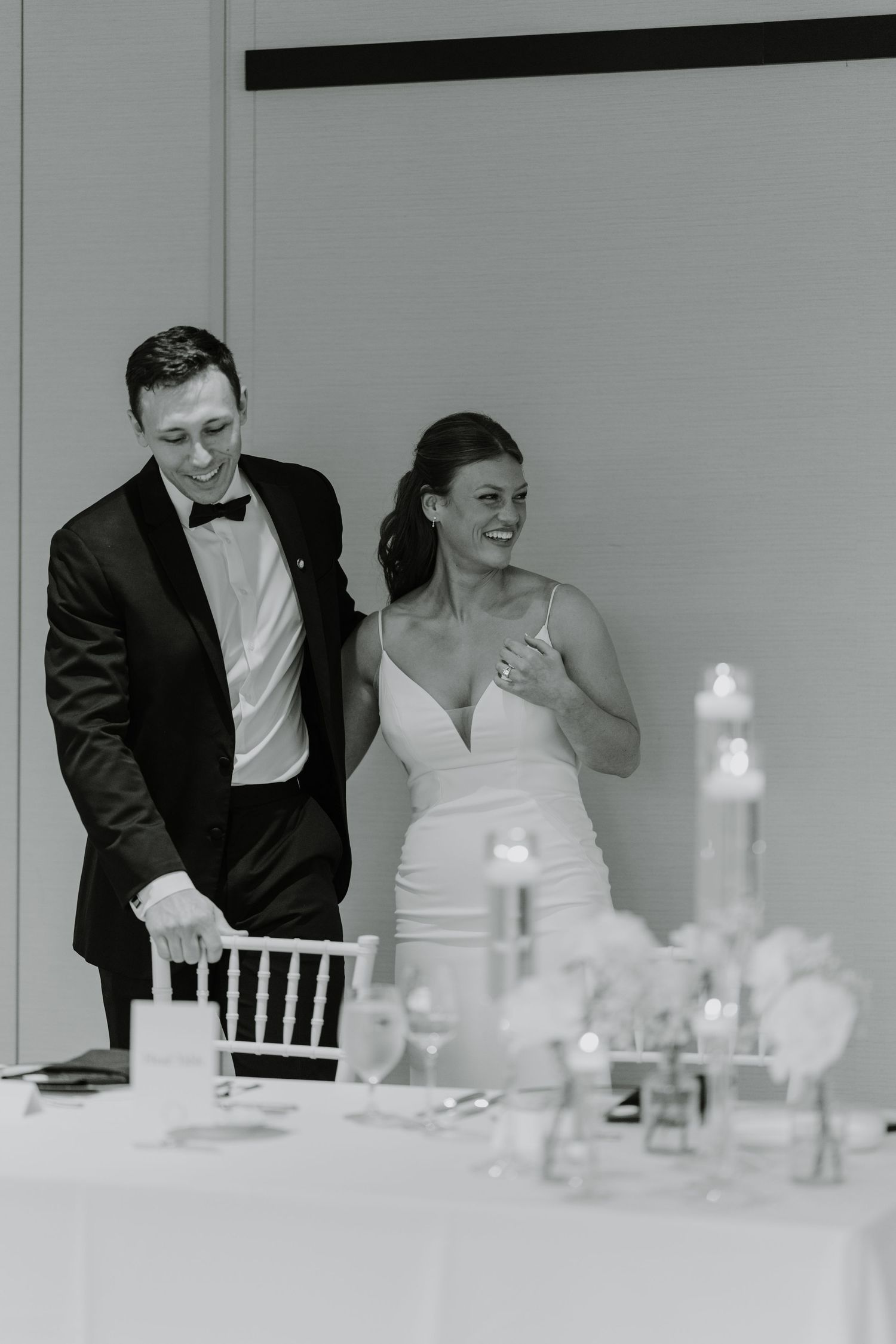 Wedding couple shares intimate moment at reception table with soft candlelight.