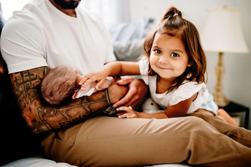 A sweet moment shared between family members on a comfortable couch with a newborn.