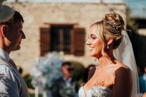 A joyful wedding celebration with guests dancing and laughing at an outdoor reception venue.