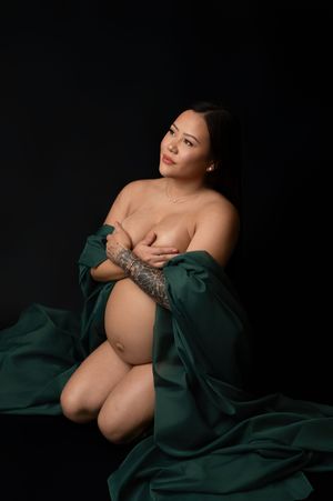 Artistic boudoir photography series featuring emerald green silk fabric against dark background.
