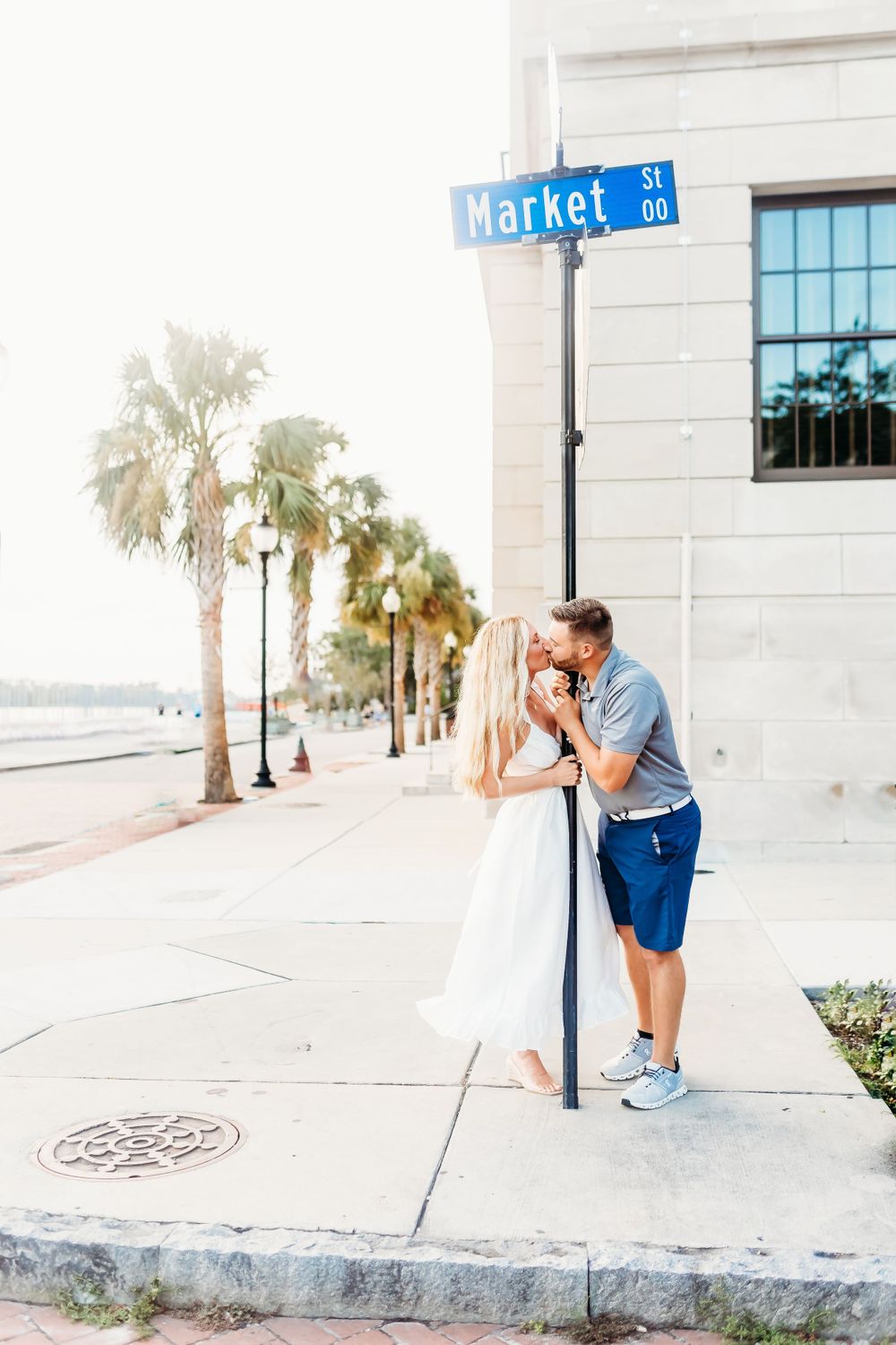 Couple posing by Market Street sign with palm trees in background.
