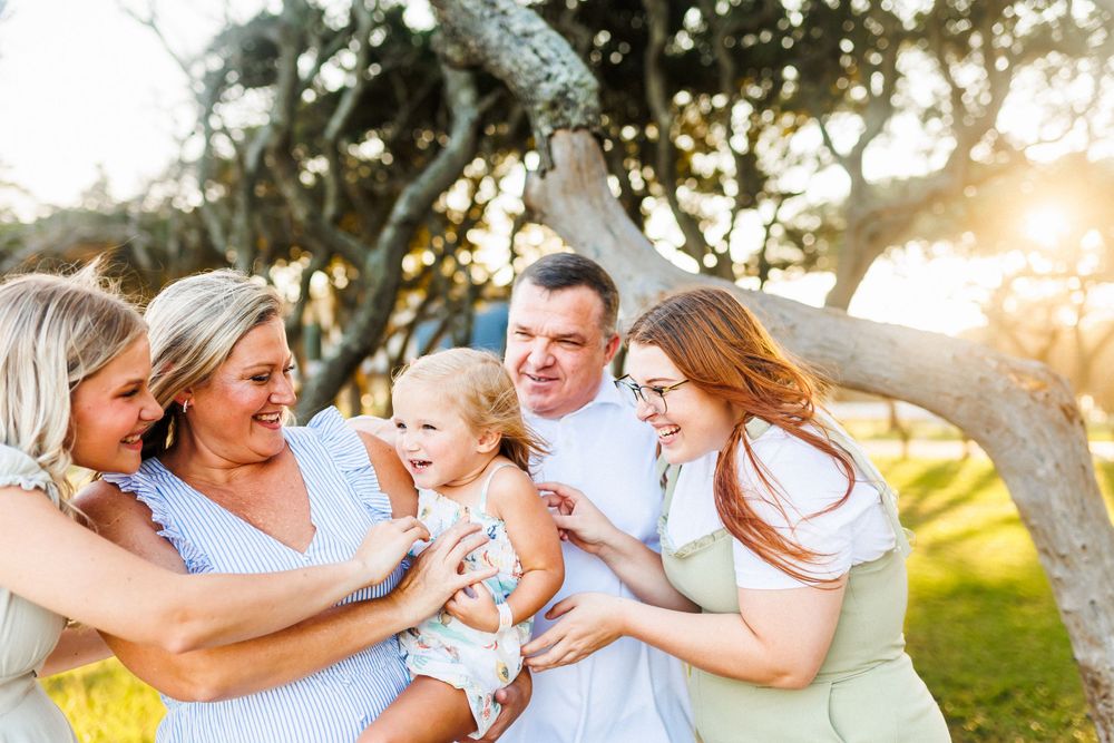 Group sharing joyful moment together outdoors during golden hour sunset.