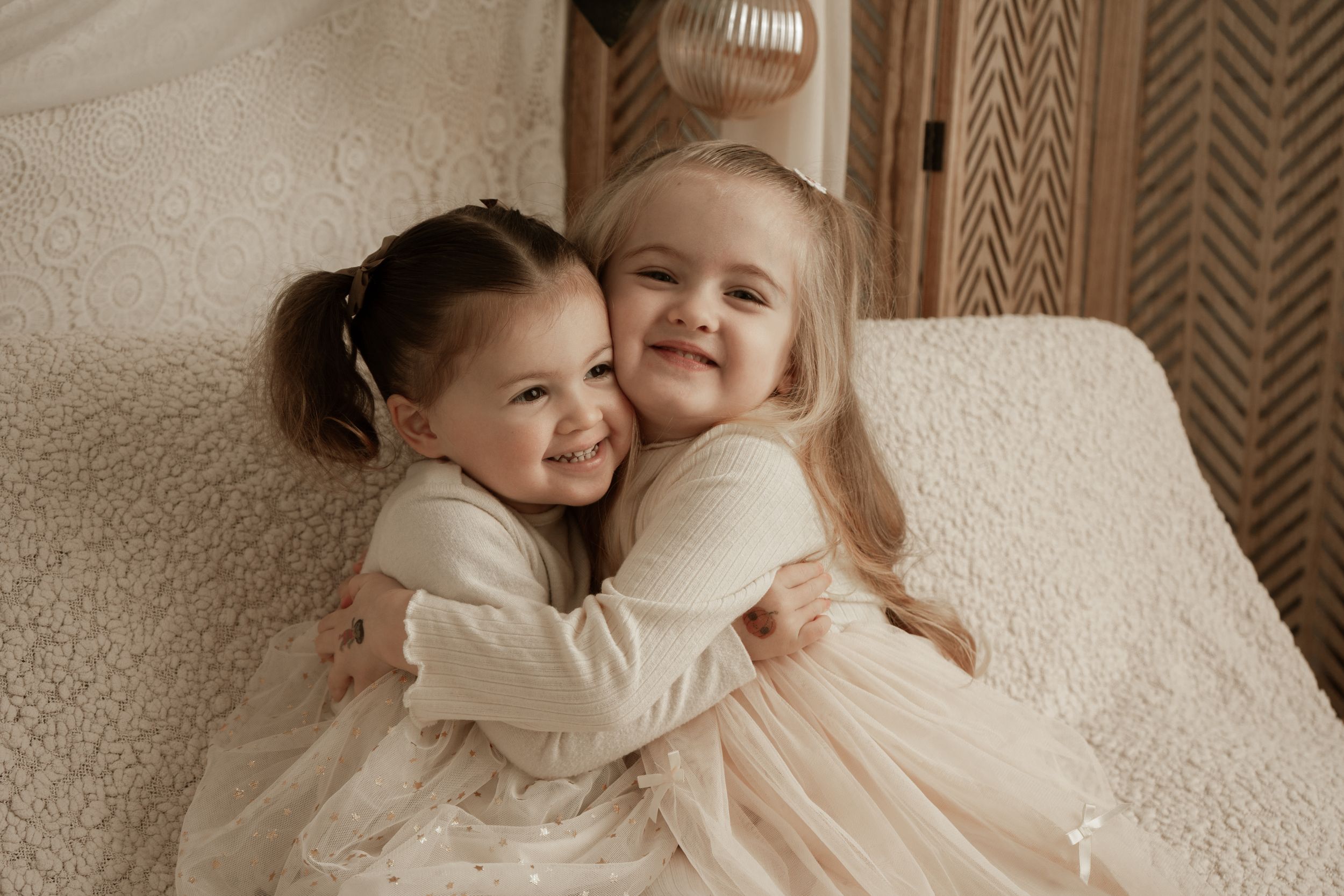 A series of tender black and white photos showing intimate family moments and embraces on a light colored background.
