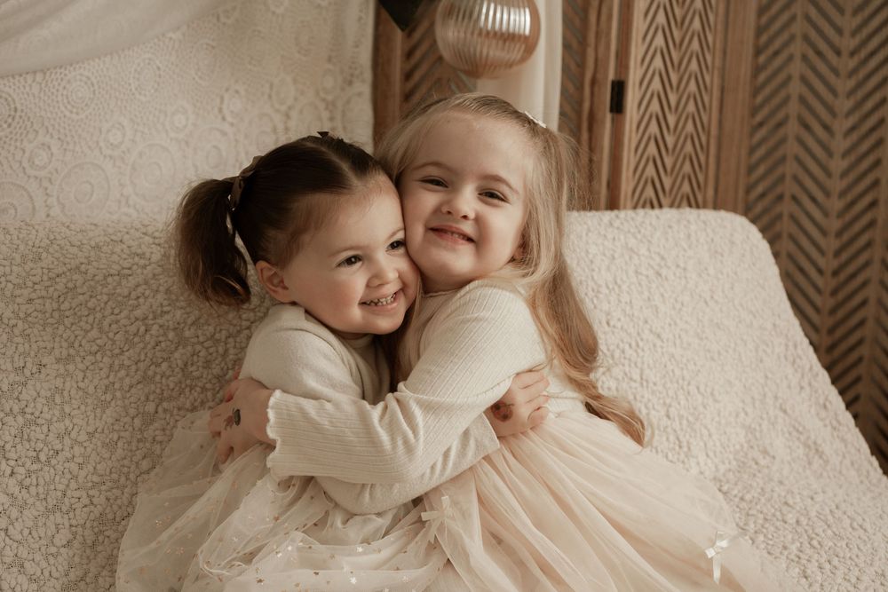 A series of tender black and white photos showing intimate family moments and embraces on a light colored background.