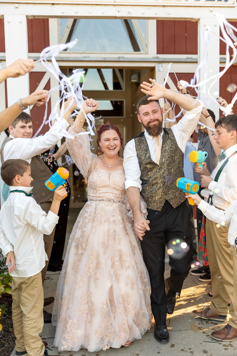 Wedding guests shower the newlyweds with white confetti as they walk together in a celebratory exit.