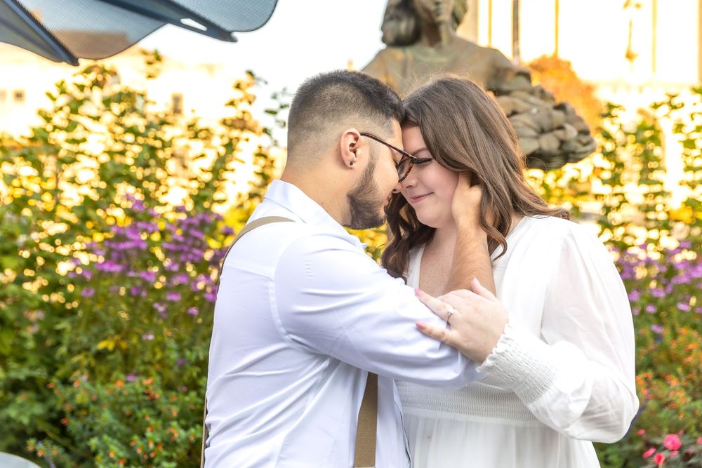 Romantic moment between couple in white attire in garden setting at sunset.