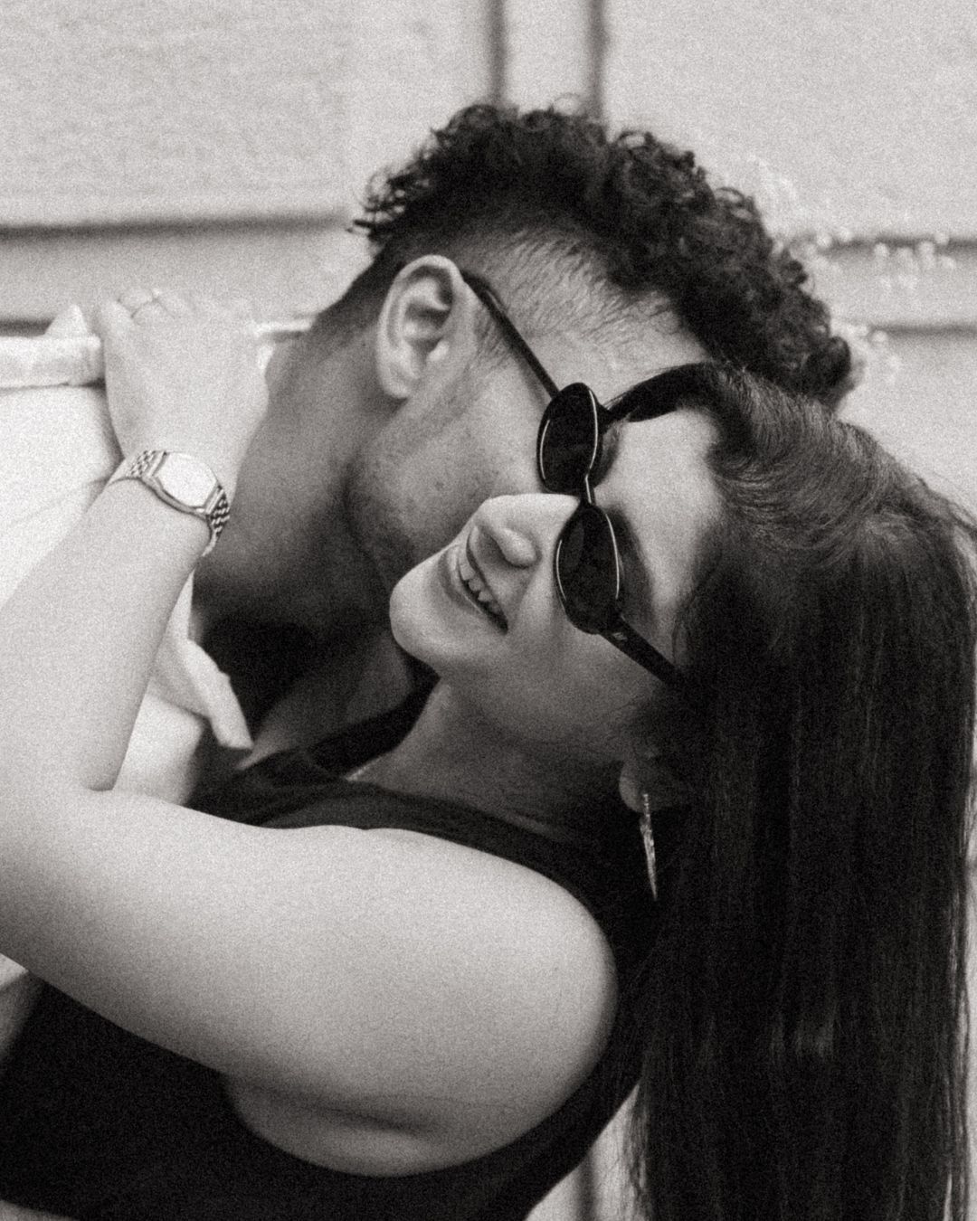 Series of intimate black and white portraits showing a couple in sunglasses embracing.