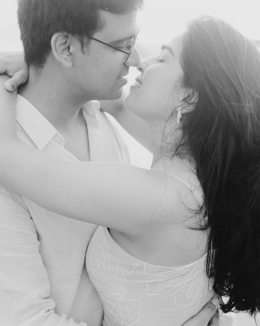 Black and white romantic portraits of a couple sharing intimate moments.