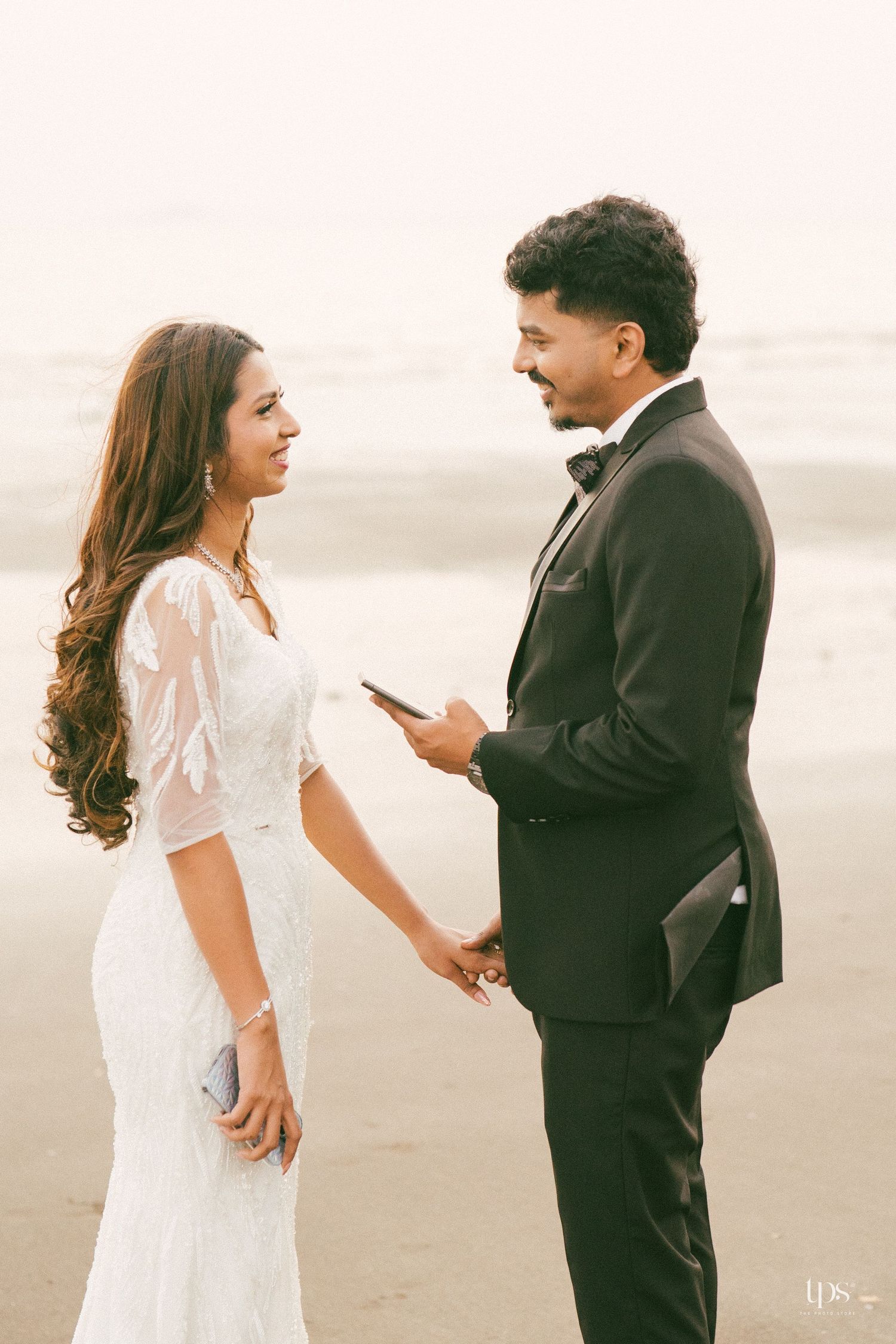 A romantic moment between newlyweds on a misty beach.