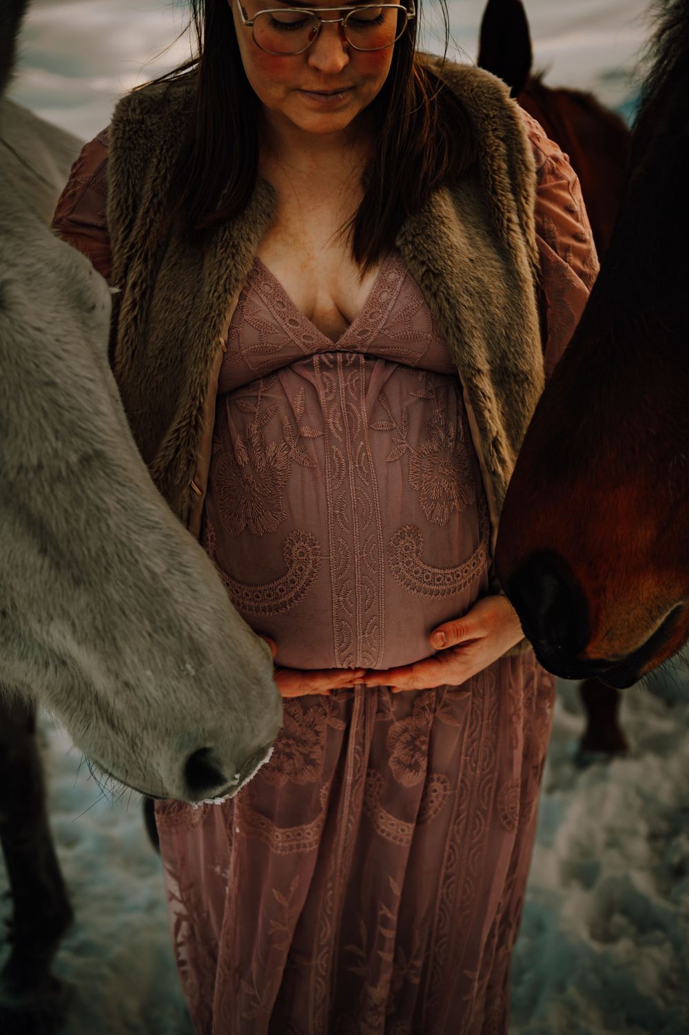Close-up of an expectant mother in a mauve dress with a horse nose visible in frame.