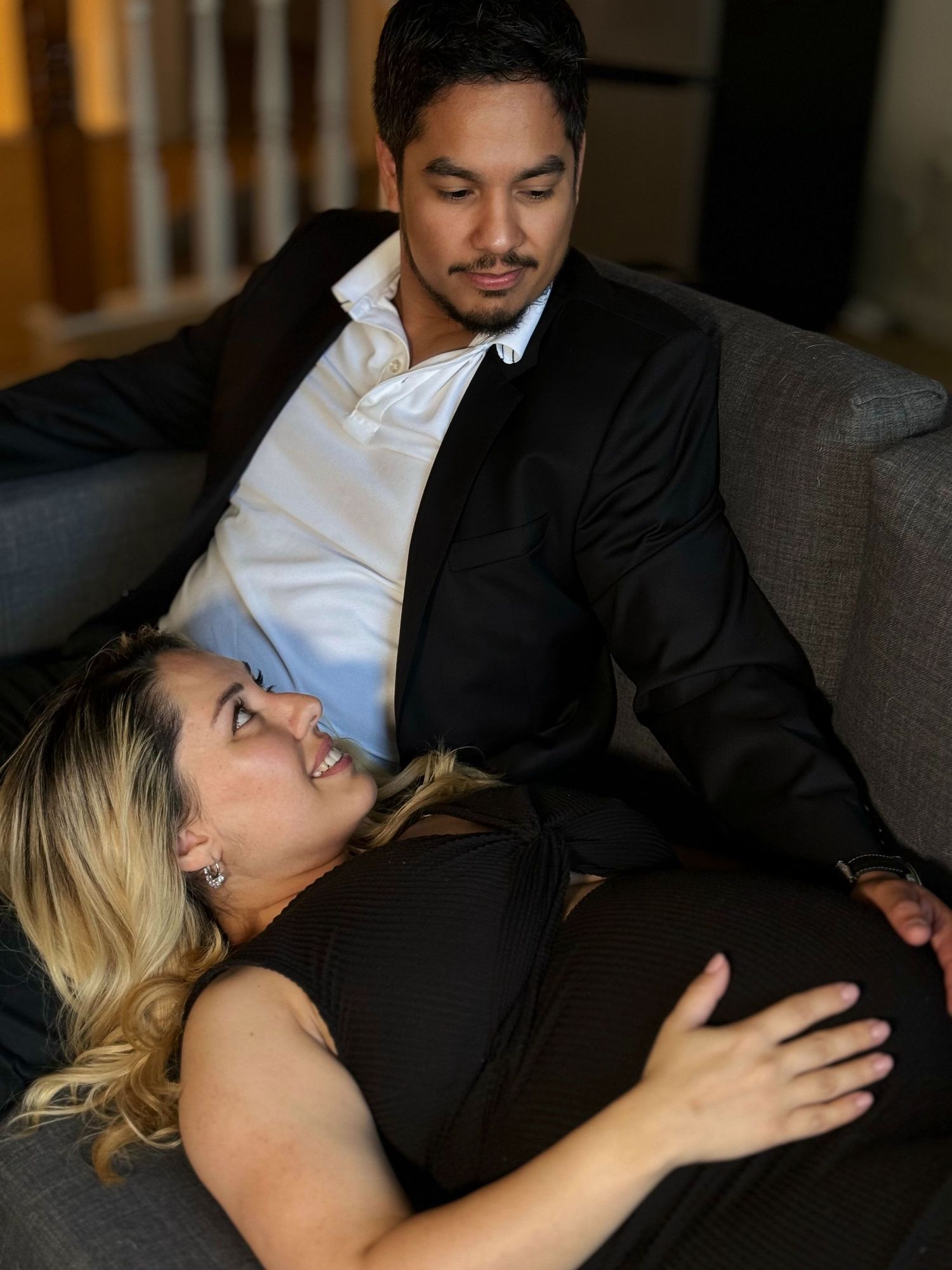 Couple shares tender moments during intimate couch photoshoot.