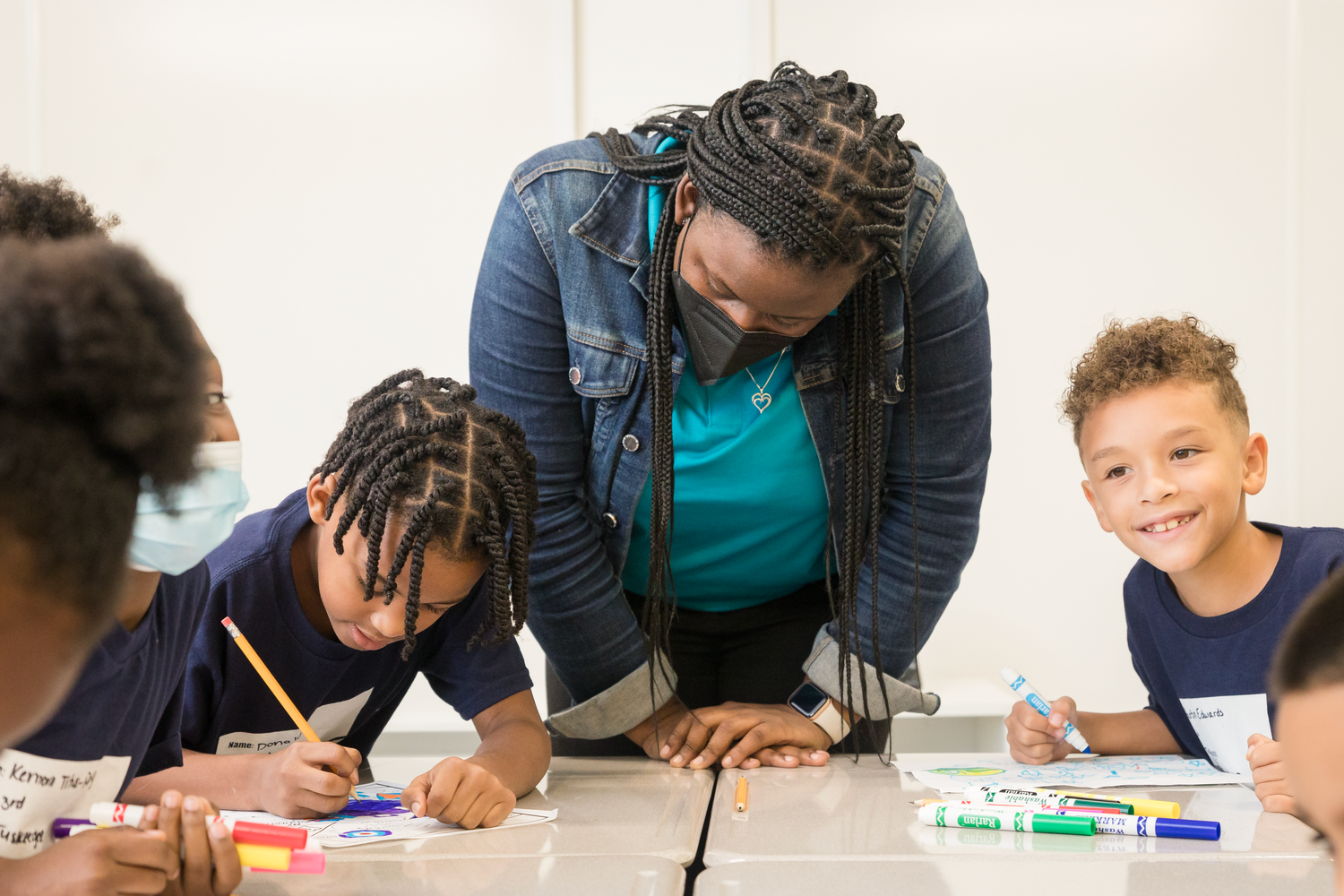 Students working on educational activities with instructors in a classroom setting.