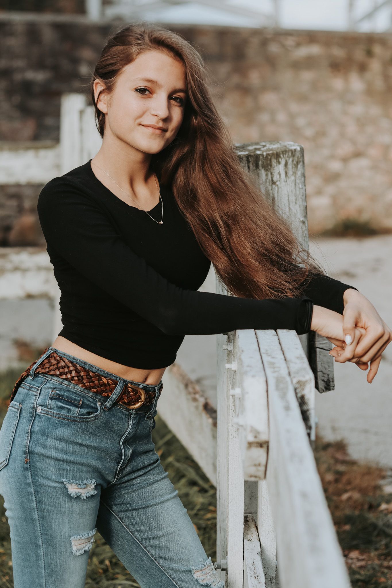 A casual portrait series showing movement and style against a rustic white fence.