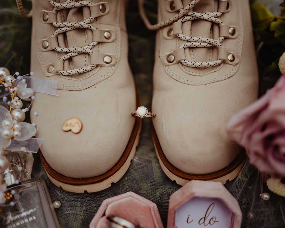 Beige combat boots surrounded by delicate pink roses and wedding decor.