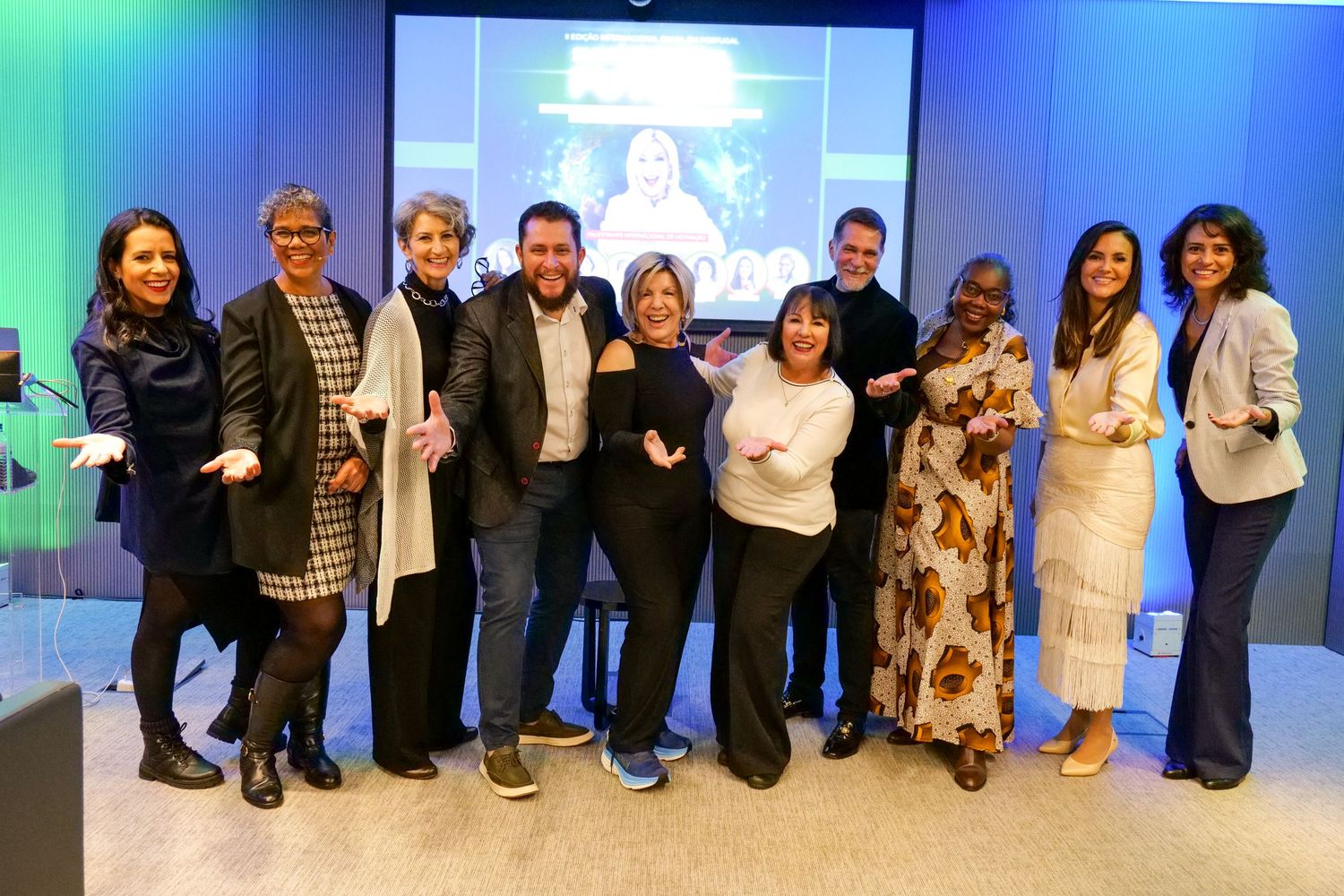 Group of ten diverse professionals posing together smiling at a corporate summit event.