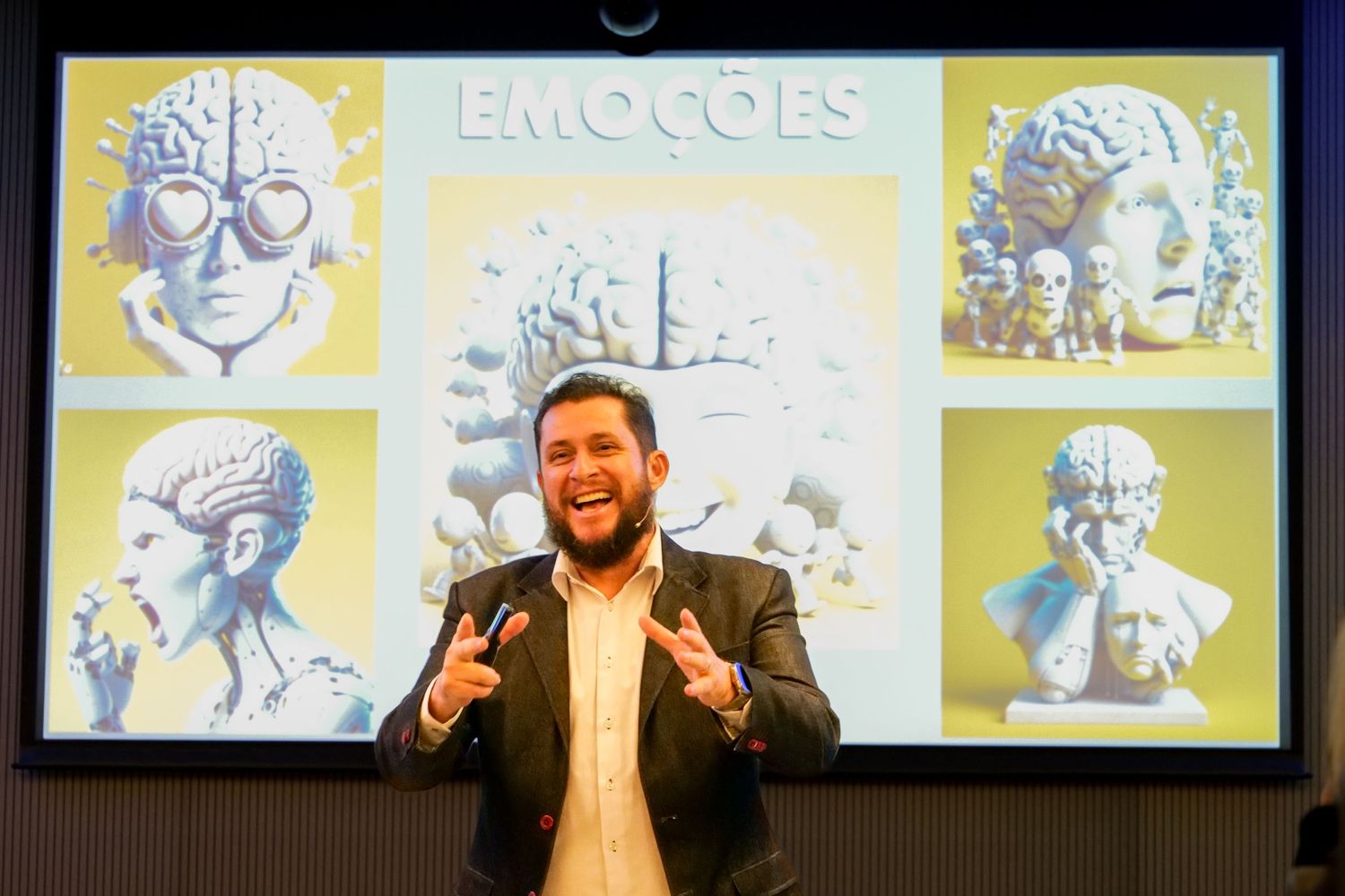 Male speaker gestures enthusiastically before a colorful Emocoes presentation slide at a conference.