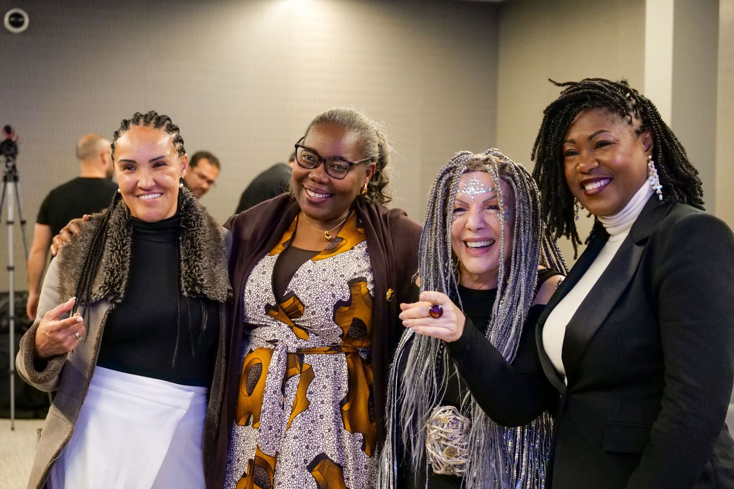 Four women smiling and posing together at a professional networking event.